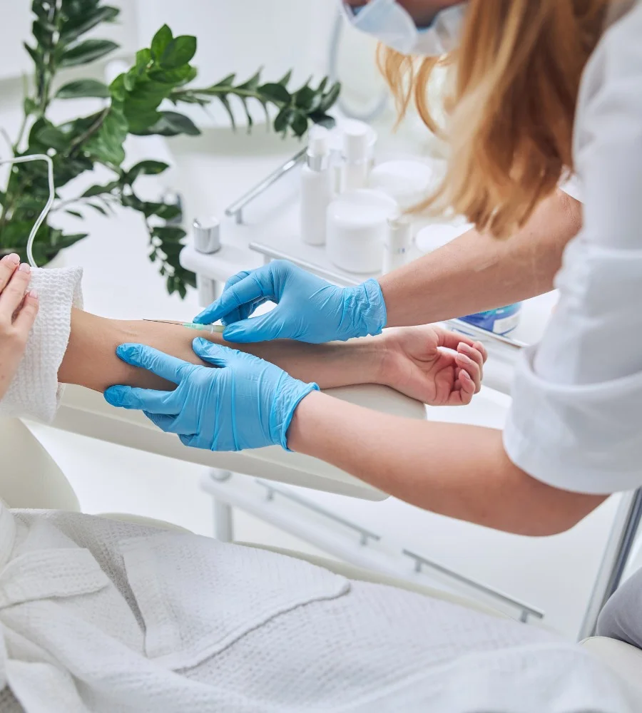 Clinician starting an IV in a patient's arm